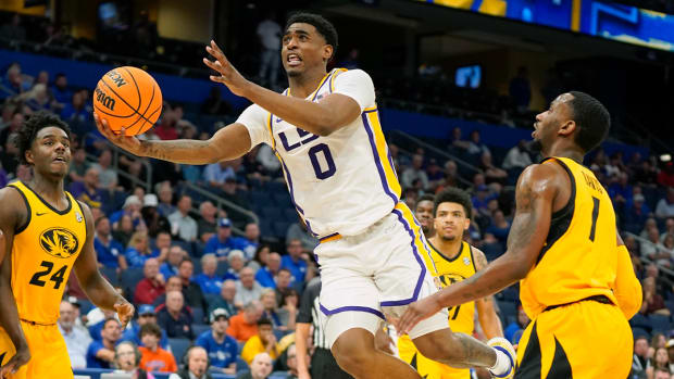 LSU guard Brandon Murray (0) goes to the basket to shoot past Missouri forward Kobe Brown (24) and guard Amari Davis, right, during the first half of an NCAA college basketball game at the Southeastern Conference tournament in Tampa, Fla., Thursday, March 10, 2022.